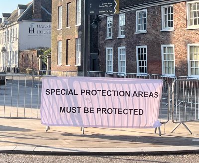 Banner reads SPECIAL PROTECTION AREAS MUST BE PROTECTED outside Kings Lynn Council Building. Credit: Lily O'Mara