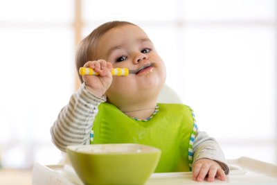 Infant child eats with a spoon. Copyright: Oksana Kuzmina | shutterstock