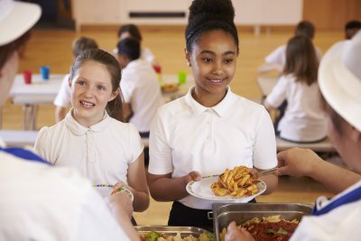 Primary school students eating school meals. Credit: Monkey Business Images