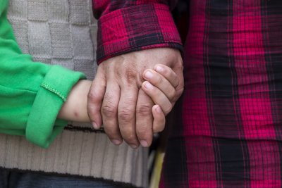 Two immigrants hold hands in Idomeni, Greece, waiting to hear about onward passage. Copyright: Ververidis Vasilis | shutterstock