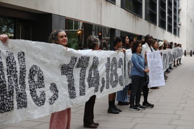 Artists and volunteers carry a 30-metre-long living artwork made of seed paper to the Department of Levelling Up, Housing and Communities. Copyright: Elizabeth Dalziel / Greenpeace