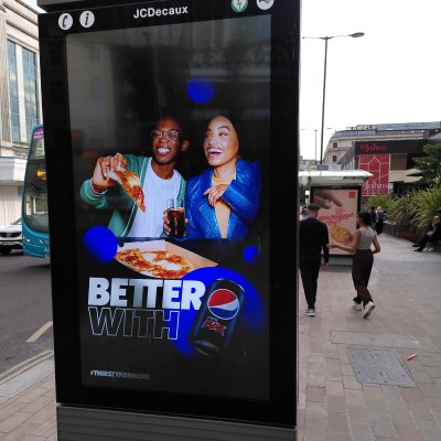 Young people walk by unhealthy food adverts on the streets of Liverpool. Credit: Fran Bernhardt