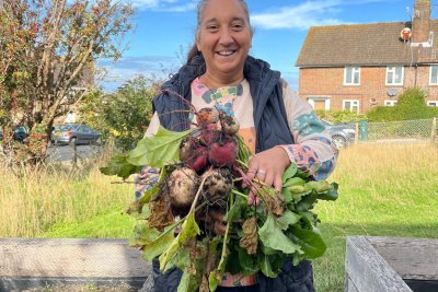 Volunteer holding beetroot from community garden. Copyright: St Richards Community Support Cafe