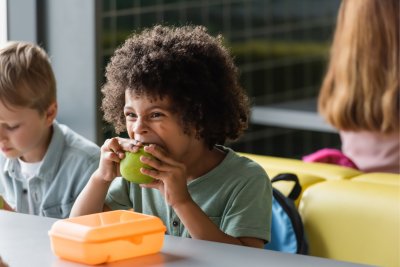 School kids enjoying snacks during lunch break. Credit: LightFieldStudios / iStock