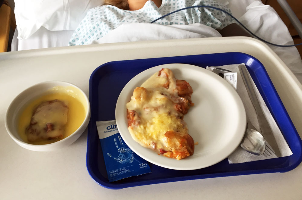 A plate of hospital food on a patients lap