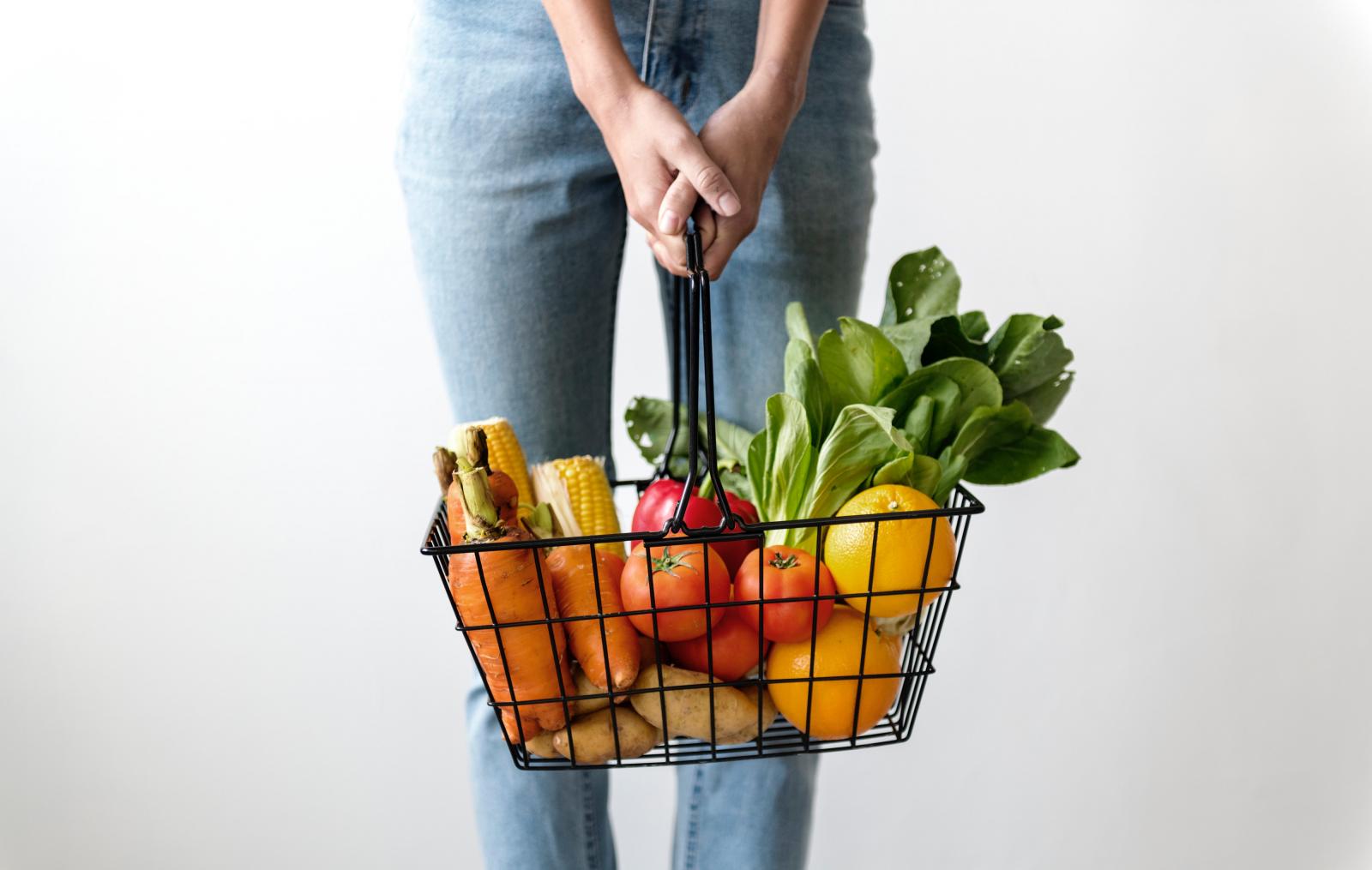 Woman holding a basket of food. Photo credit: Pexels