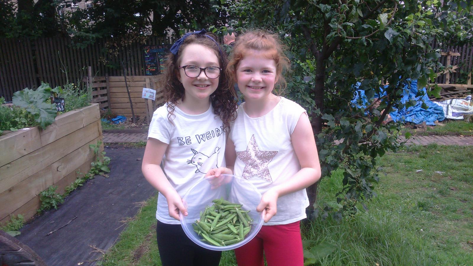 Two Glasgow residents enjoying locally grown veg. Credit: Glasgow Community Food Network